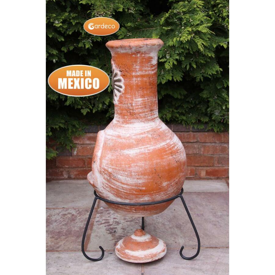 Terracotta pot on a stand with Gardeco branding and 'Made in Mexico' text, against a green bush background.