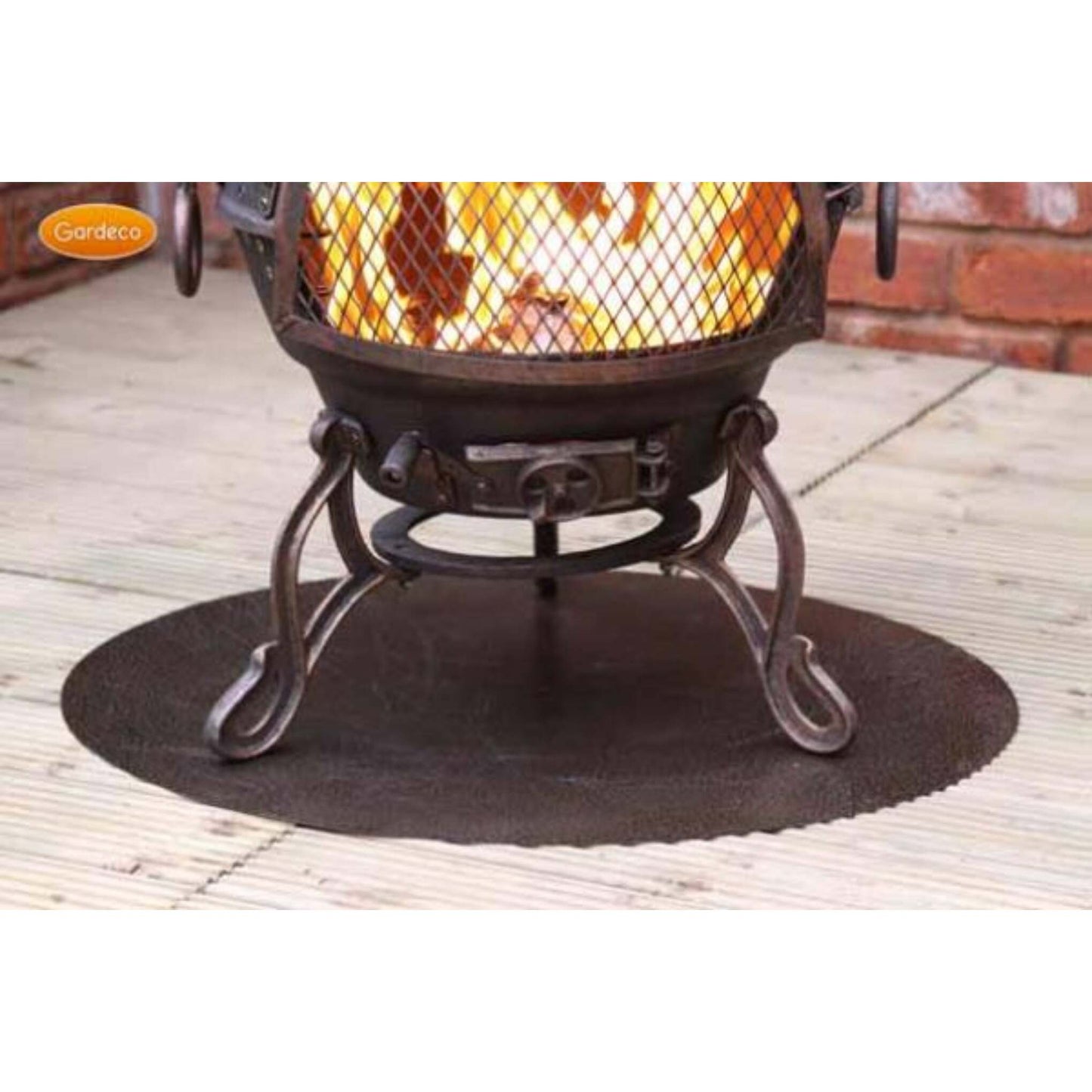 Decorative outdoor fire pit with glowing coals on a floor protector on a wooden deck
