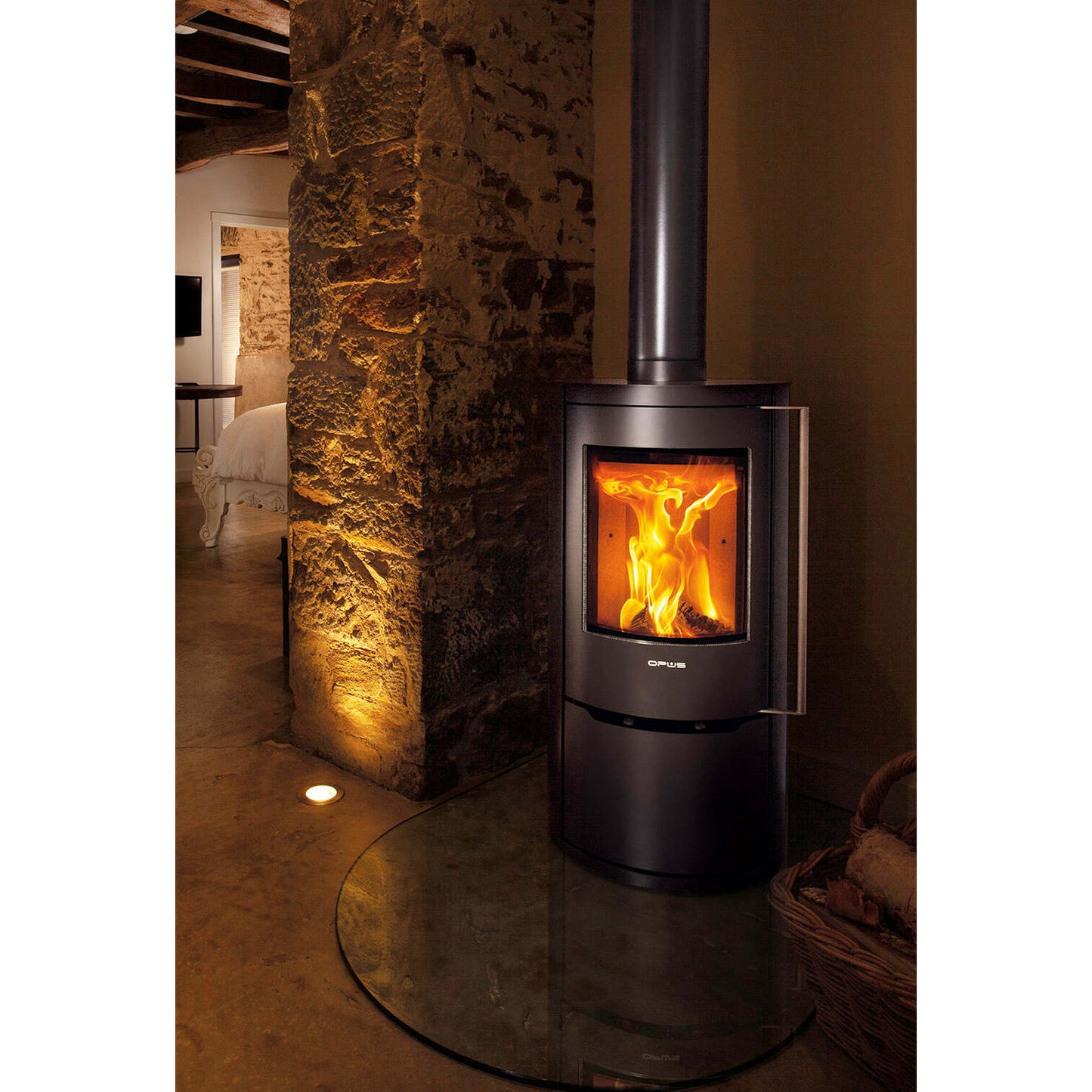 Wood-burning stove in a cozy room with stone walls and warm lighting.