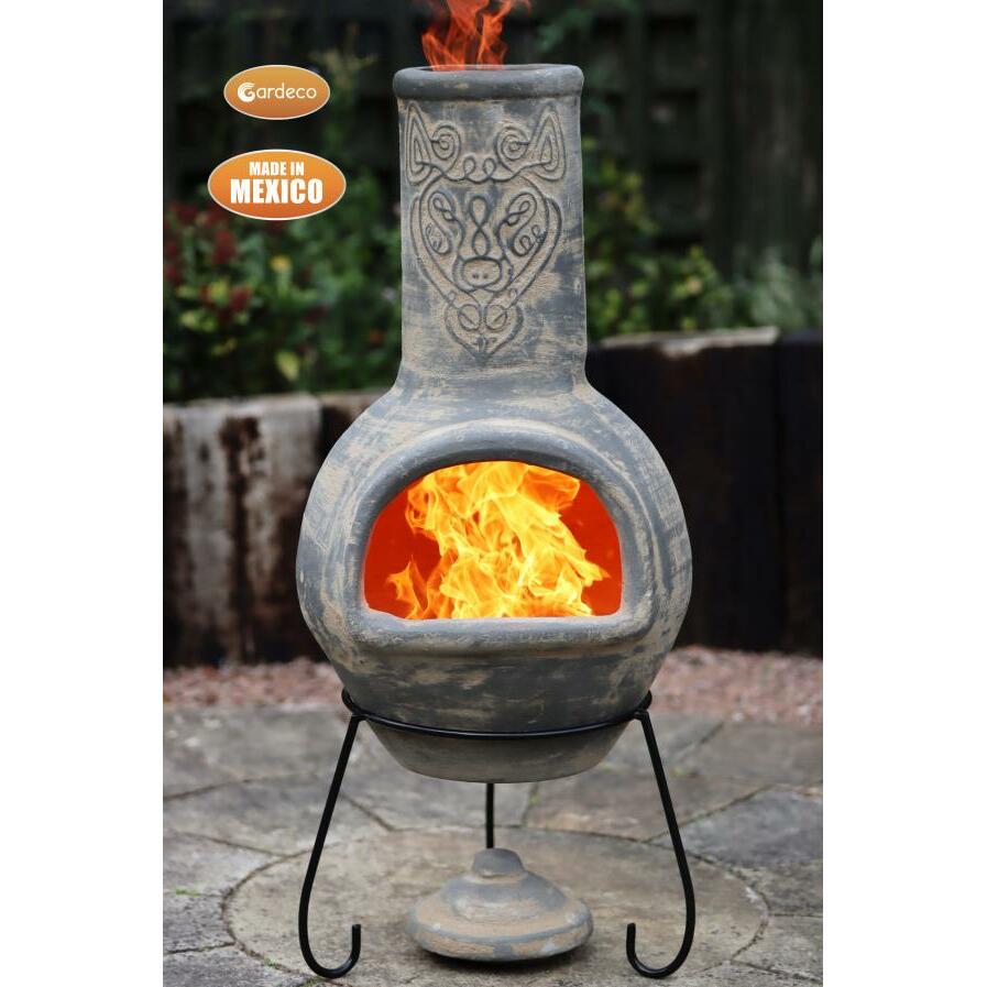 Decorative outdoor fireplace with flames, made in Mexico, on a stone patio.