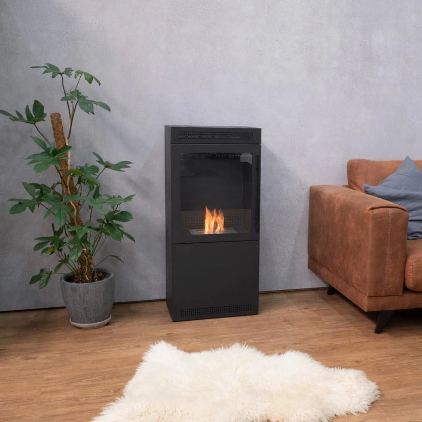 Modern living room with a black freestanding fireplace, potted plant, and brown armchair.