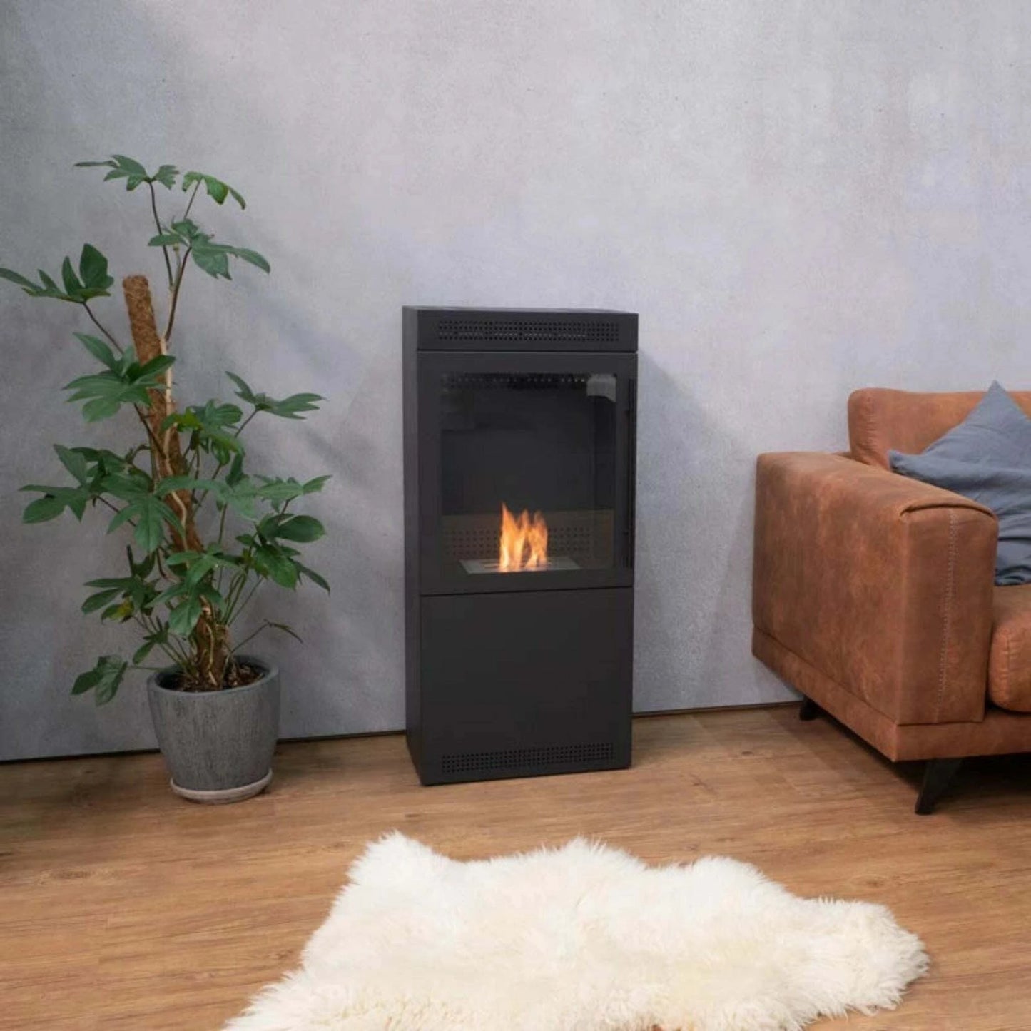 Modern living room with a black freestanding fireplace, potted plant, and brown armchair.