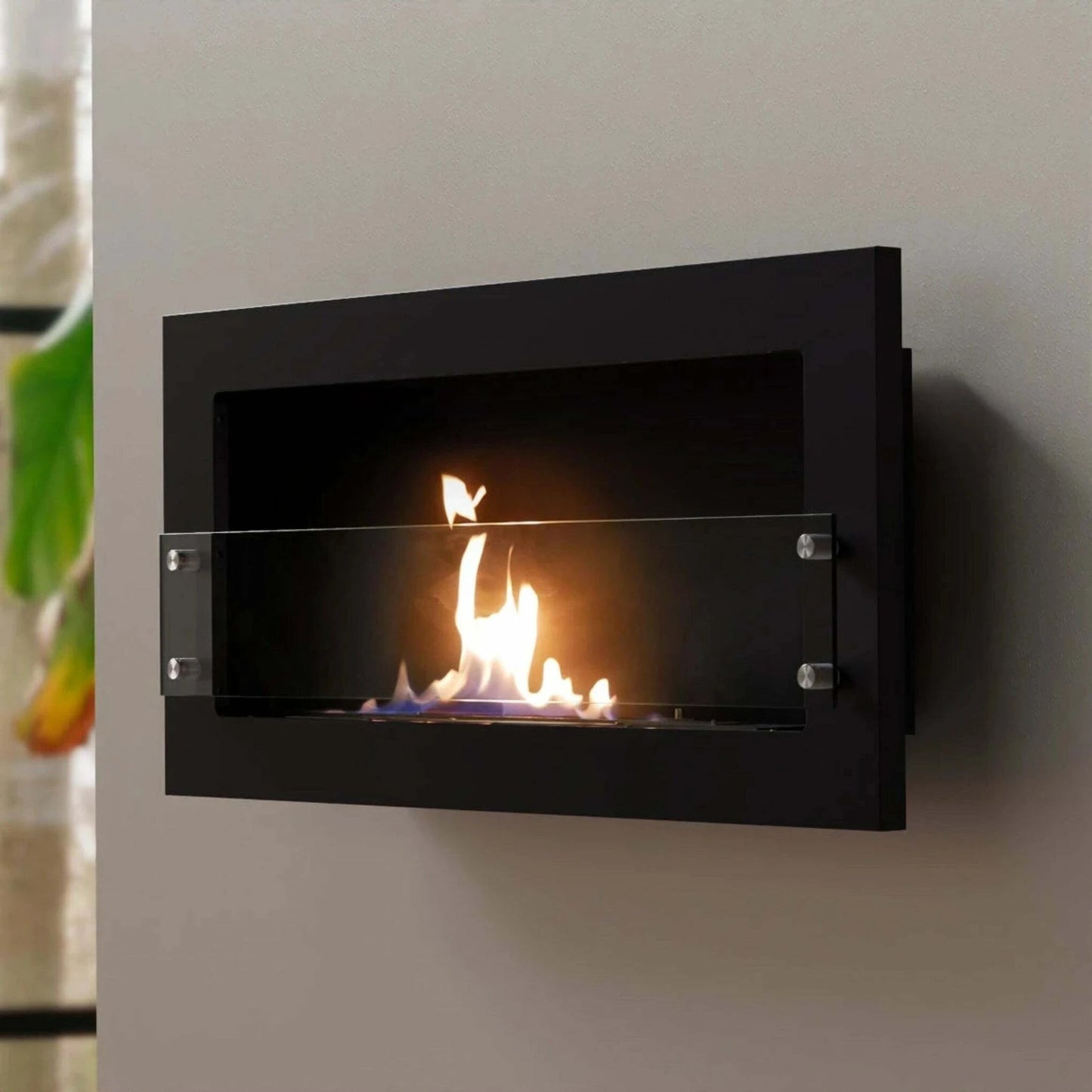 Scandiflames Texas Black stove on cream wall with plant in background