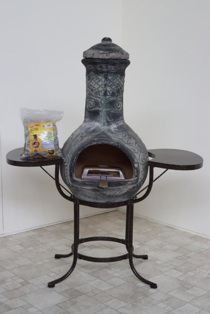 Decorative outdoor fireplace with a small table on a tiled floor.