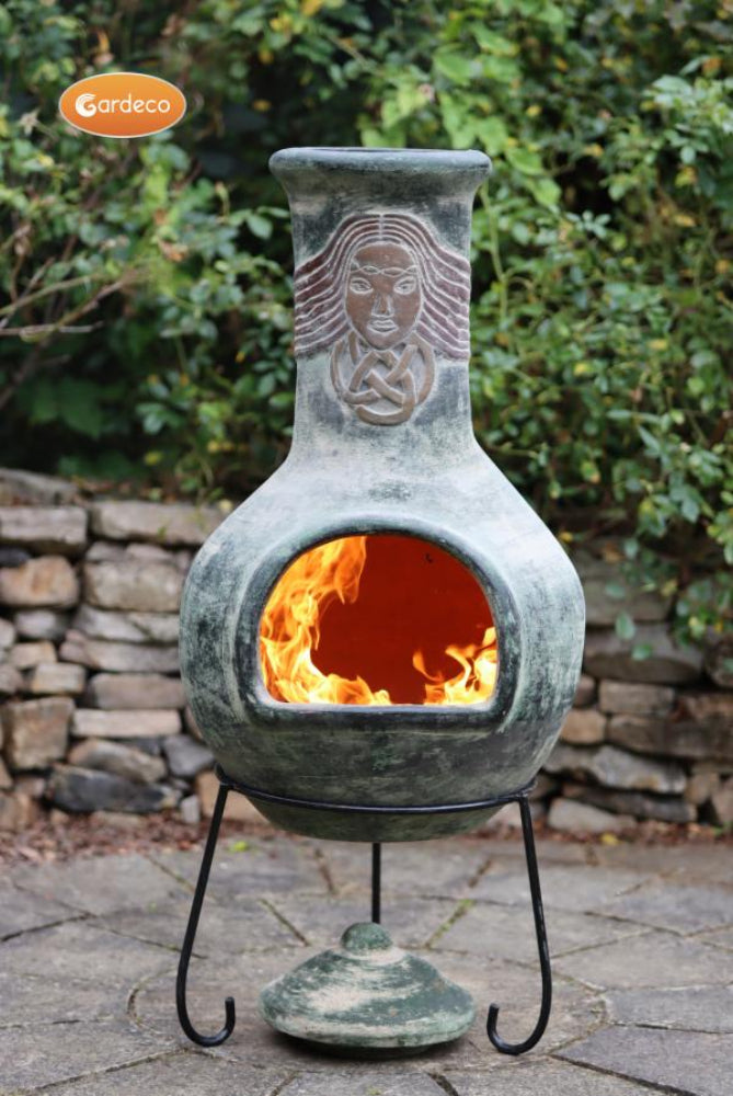 Decorative outdoor fireplace with a face design on a stone patio.