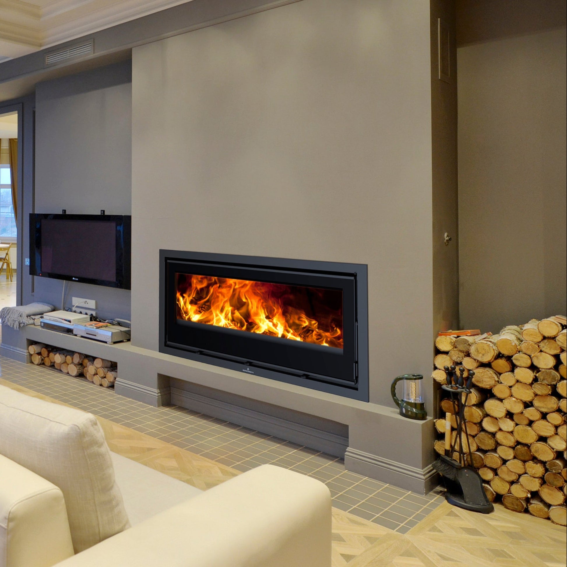 Modern living room with a Bronpi Cairo 110 fireplace, TV, and stacked firewood.