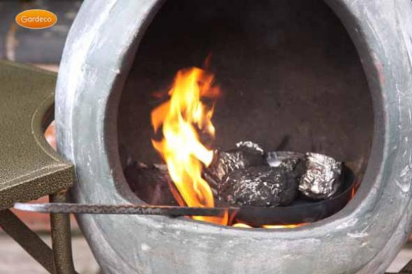 Fire pit with flames inside with food wrapped in foil