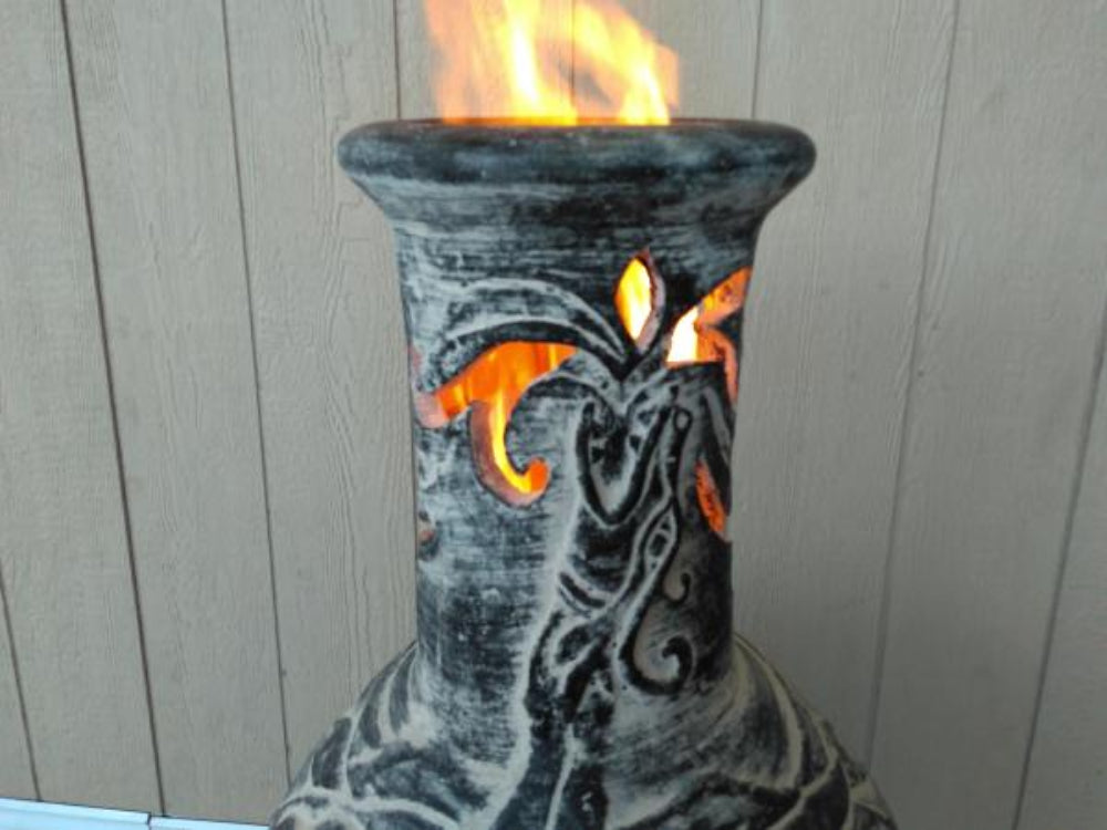 Close up of chimney of Wyre EL Dragon Mexican Chiminea – Charcoal Grey with wood plank background