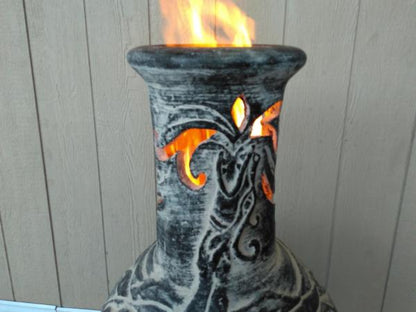 Close up of chimney of Wyre EL Dragon Mexican Chiminea – Charcoal Grey with wood plank background