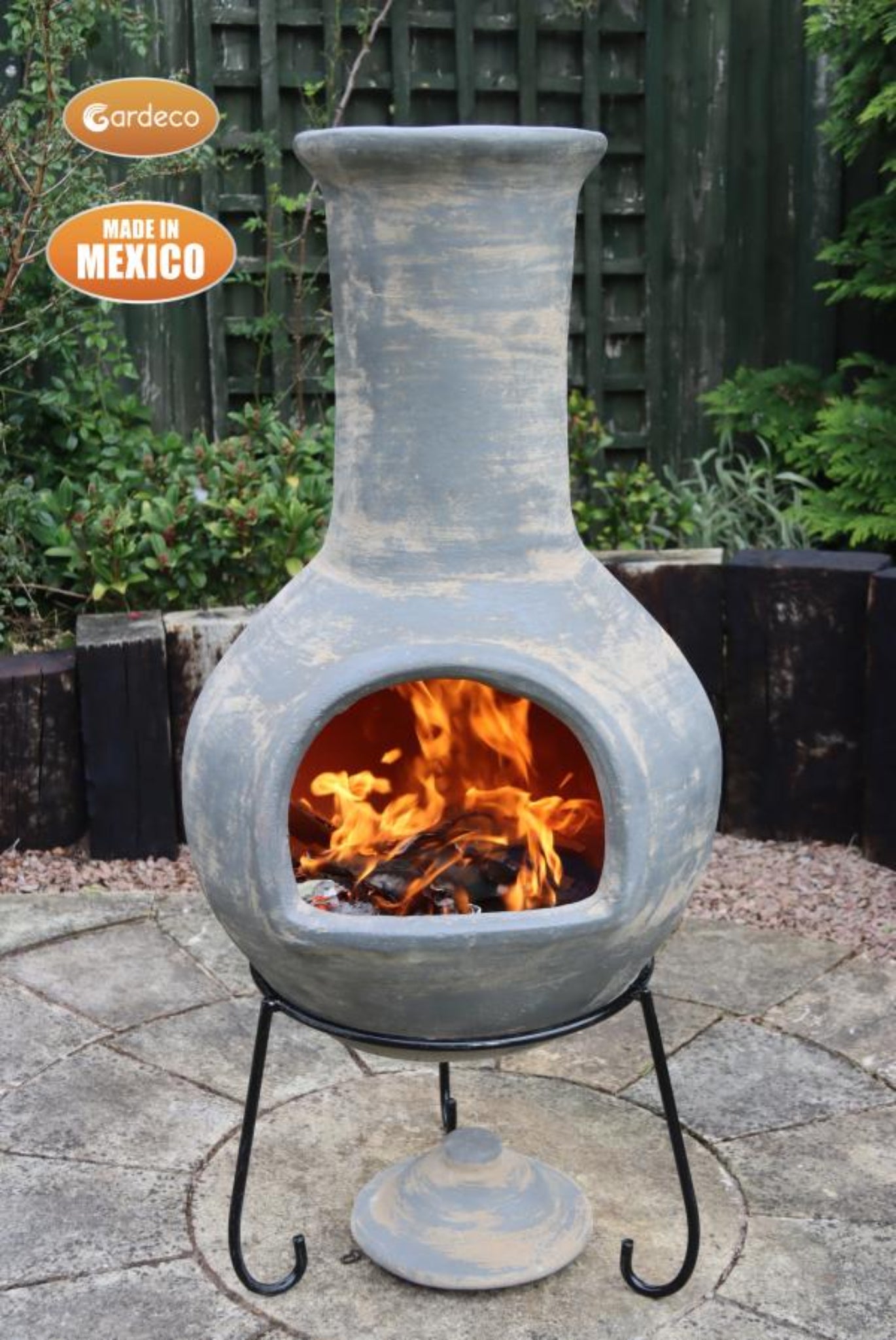 Ceramic chiminea with fire burning inside on a patio, made in Mexico by Gardeco.