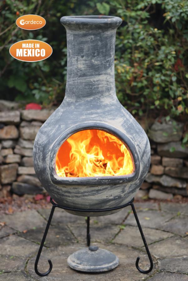Ceramic chiminea with flames inside, made in Mexico, on a patio.