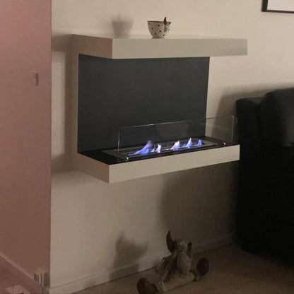 Modern wall-mounted fireplace with a soft toy on the floor and a sofa to the side.
