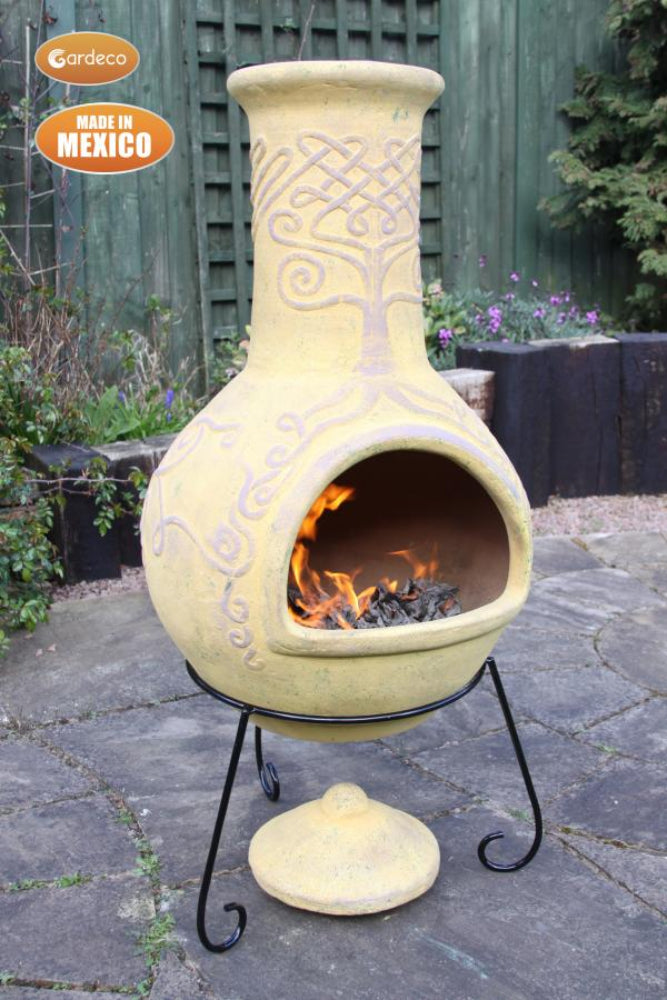 Ceramic chiminea with fire burning on a stone patio, made in Mexico by Gardeco.
