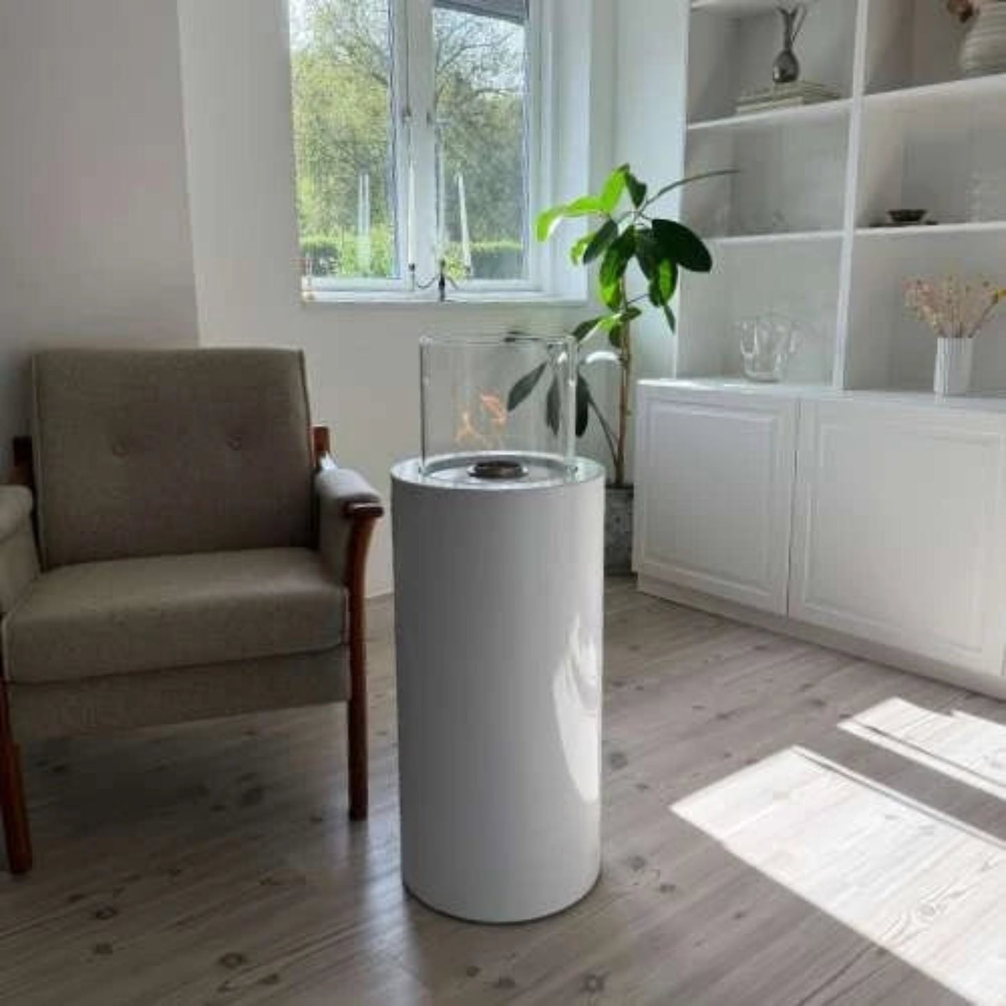 Modern living room with a cylindrical white fire pit and a plant.