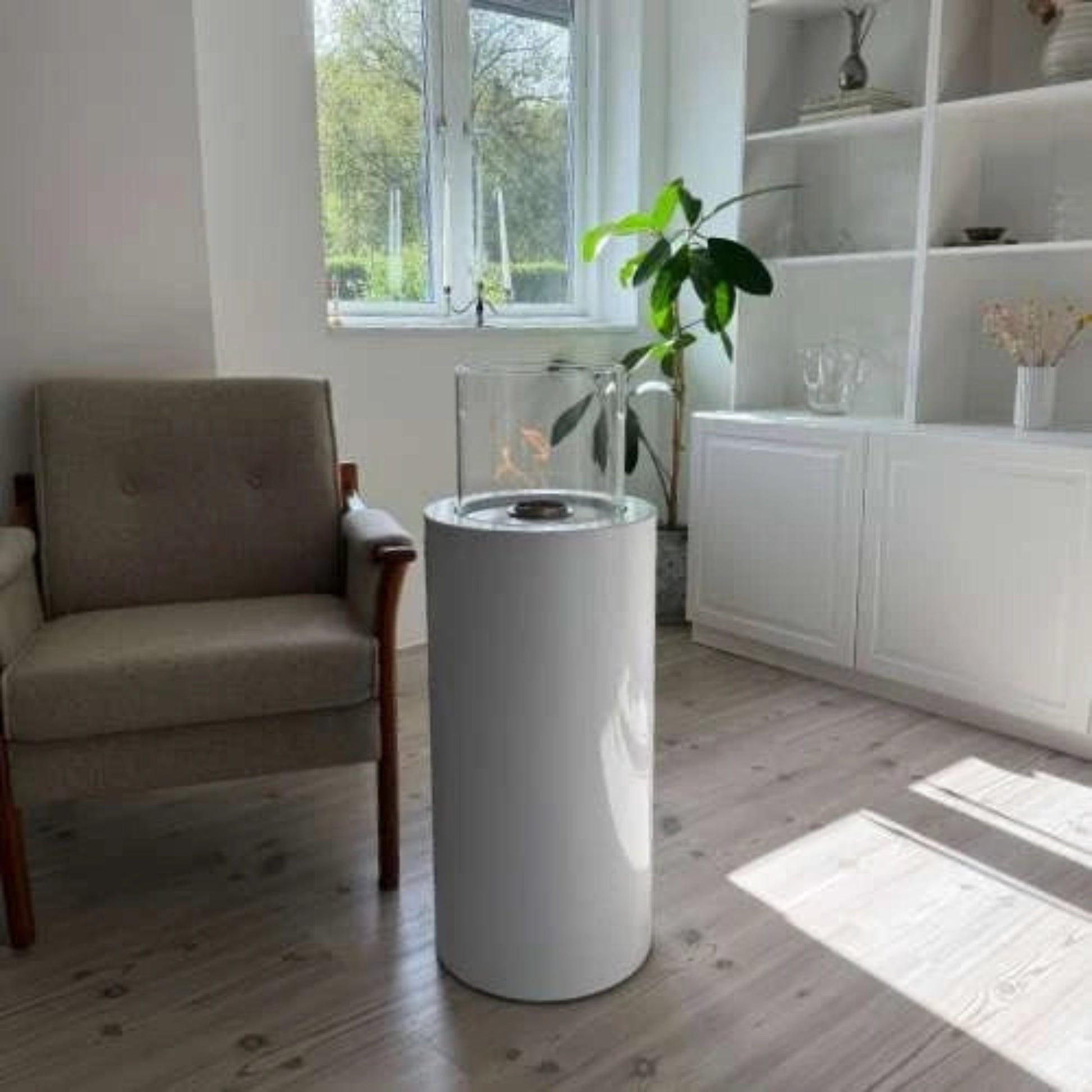 Modern living room with a cylindrical white fire pit and a plant.