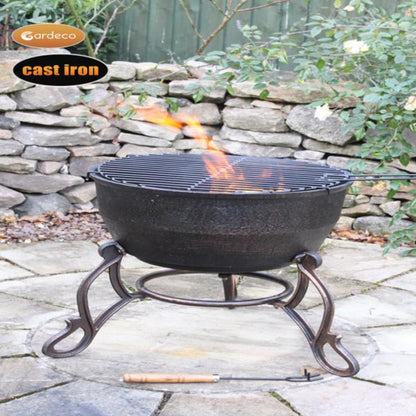 Cast iron fire pit with flames on a stone patio, Gardeco branding visible.