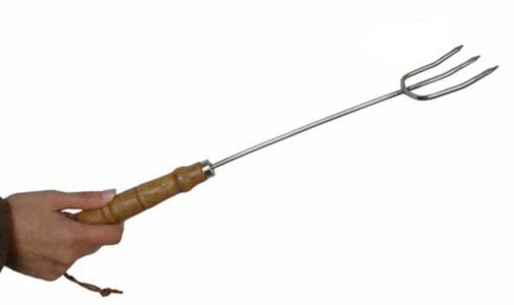 Hand holding a metal toasting fork with wooden handle on a white background.