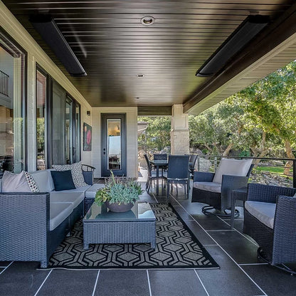 Heatbar Pro 2400 Outside Patio Heater in an outdoor patio with wicker furniture, rug, and potted plants on a sunny day.