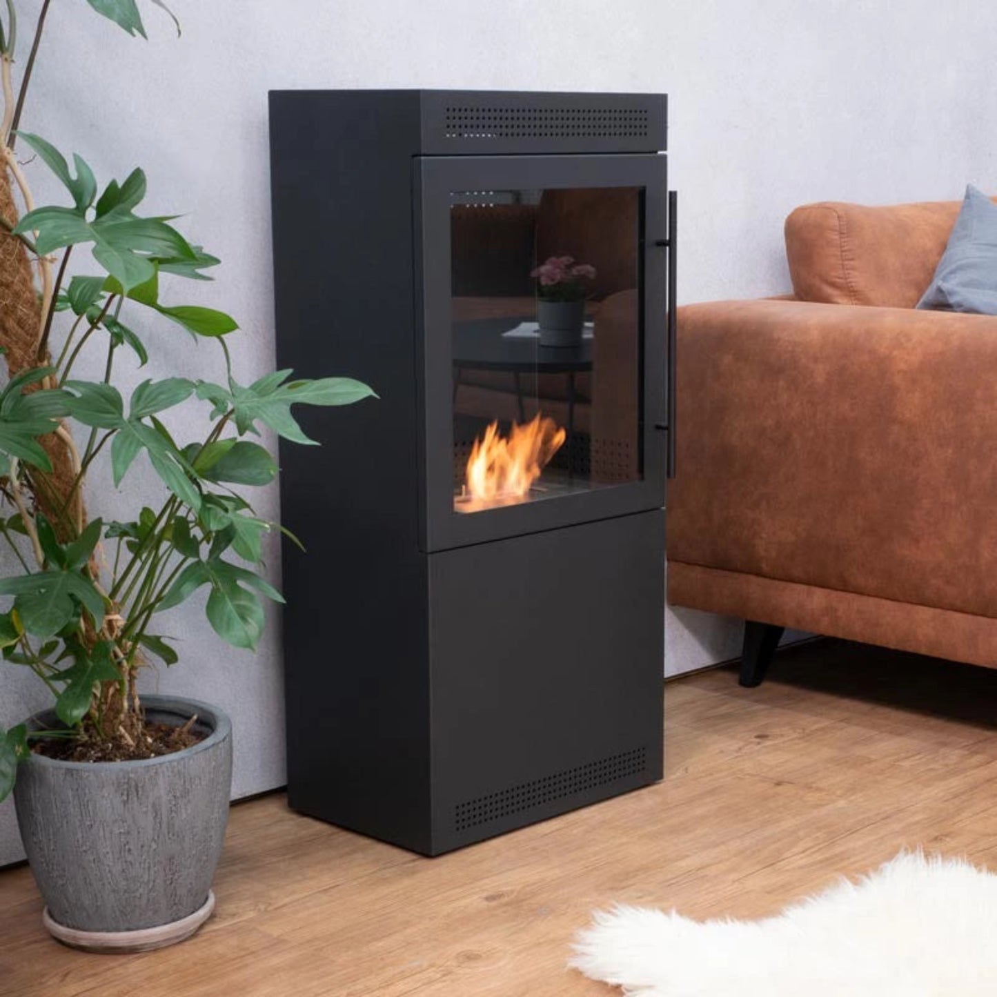 Modern black freestanding fireplace with flames in a living room setting.