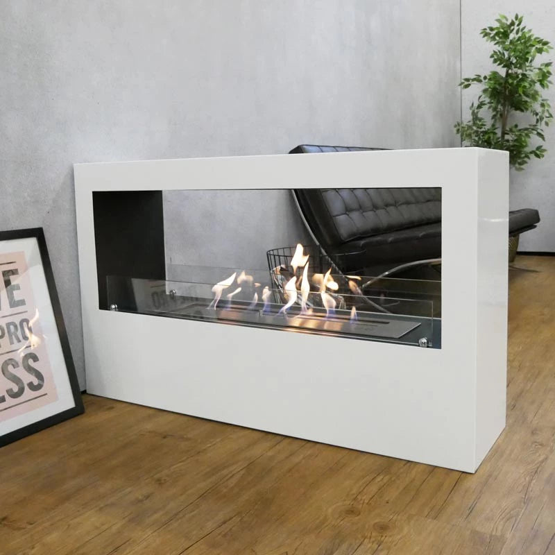 Modern white fireplace with flames in a room with a plant and framed picture.