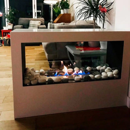 Modern bioethenol fireplace with decorative stones and glass in a living room setting.
