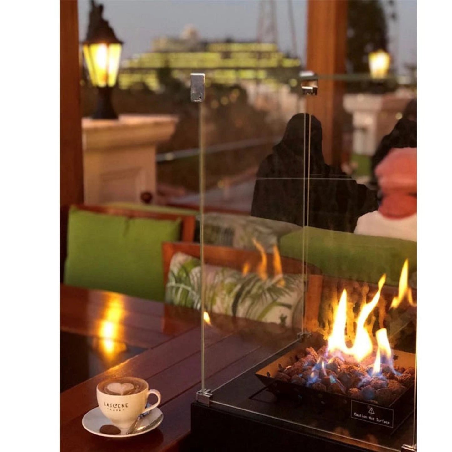 Outdoor setting with a fire pit and a cup of coffee on a table.