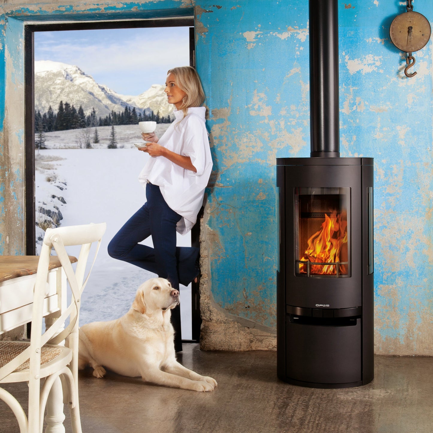 Opus_Trio_Scala_Gas_Stove in old room with blue walls, a lady drinking coffee and a white labrador