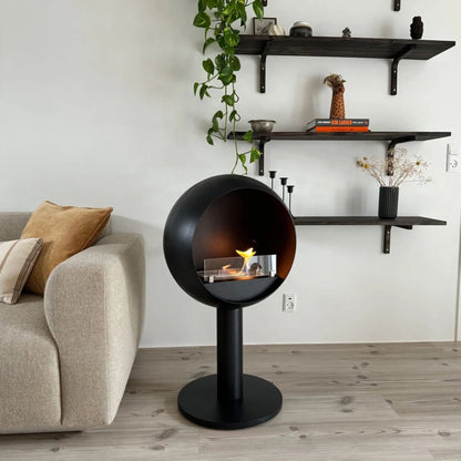 Modern living room with a spherical black fireplace and wall shelves.