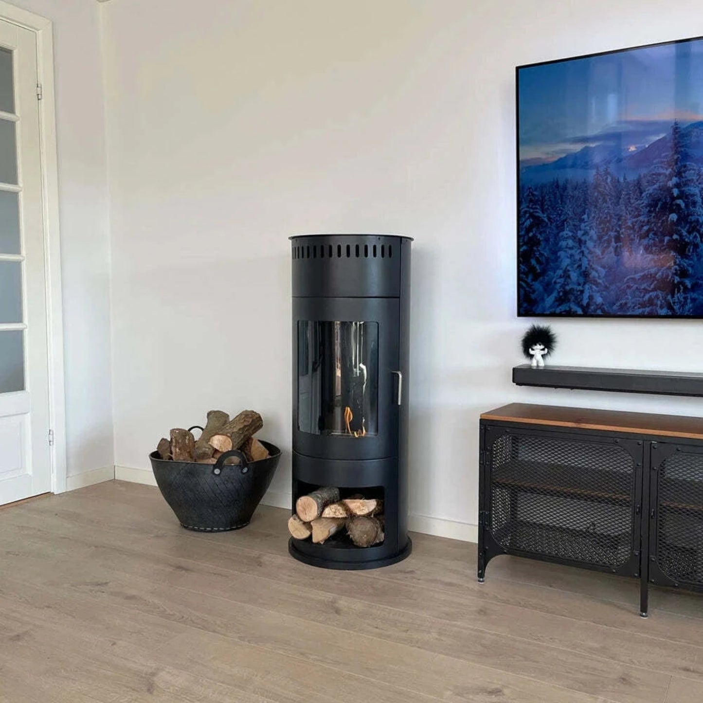 ScandiFlames Washington Bioethanol Stove in white room with logs in a metal basket, table and picture