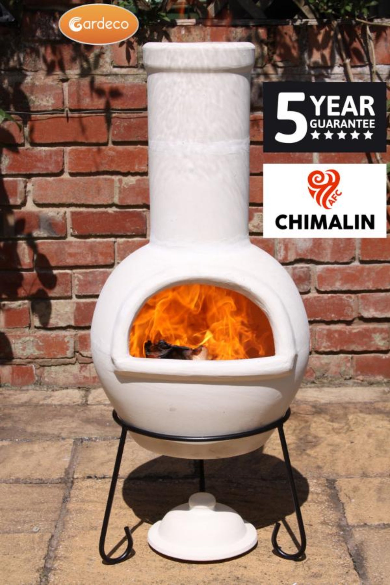 White outdoor fireplace with fire burning inside, branded 'Chimalin' and 'Gardeco'.