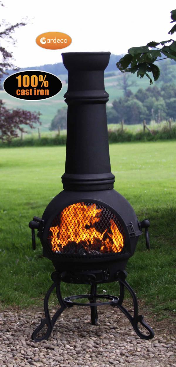 Black cast iron chiminea with flames on a grassy background