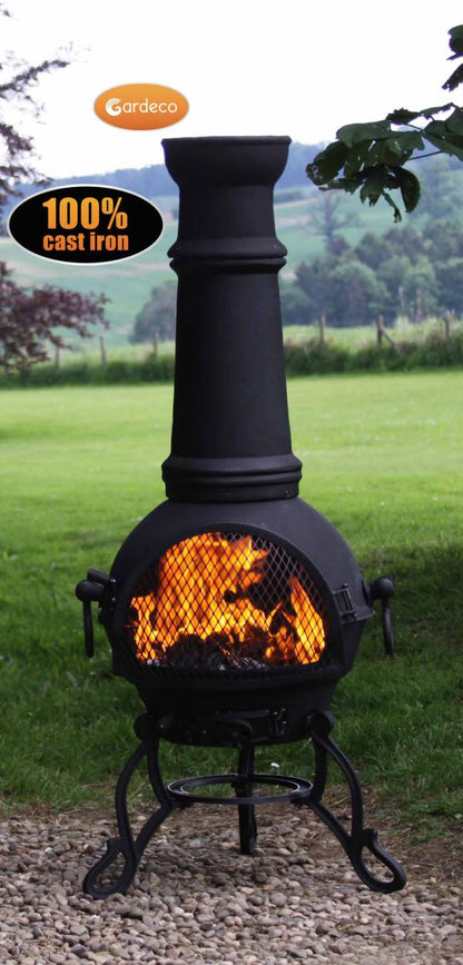 Black cast iron chiminea with flames on a grassy background