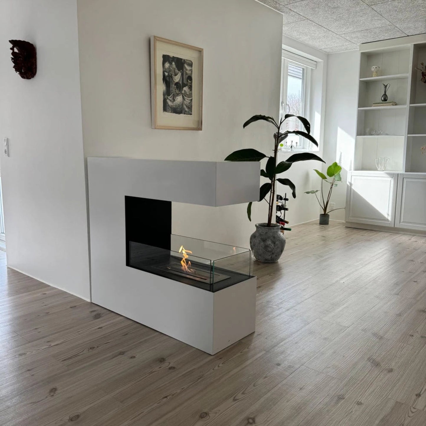 Modern living room with a white fireplace and wooden floor.