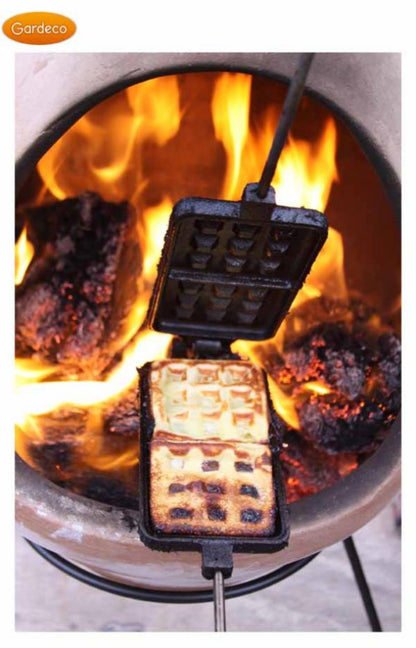 Waffle maker with waffles being cooked over an open flame, brand 'Gardeco' visible.