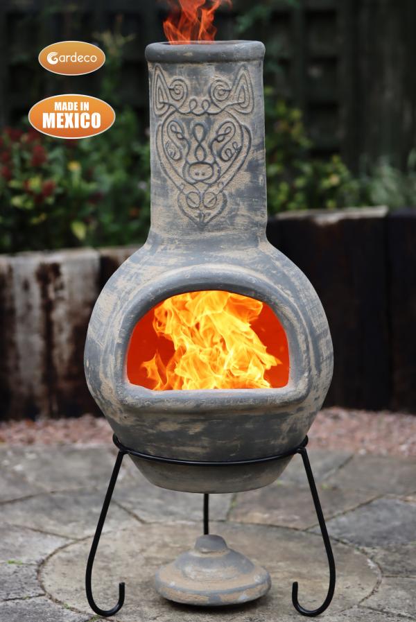 Decorative outdoor fireplace with flames, made in Mexico, on a stone patio.