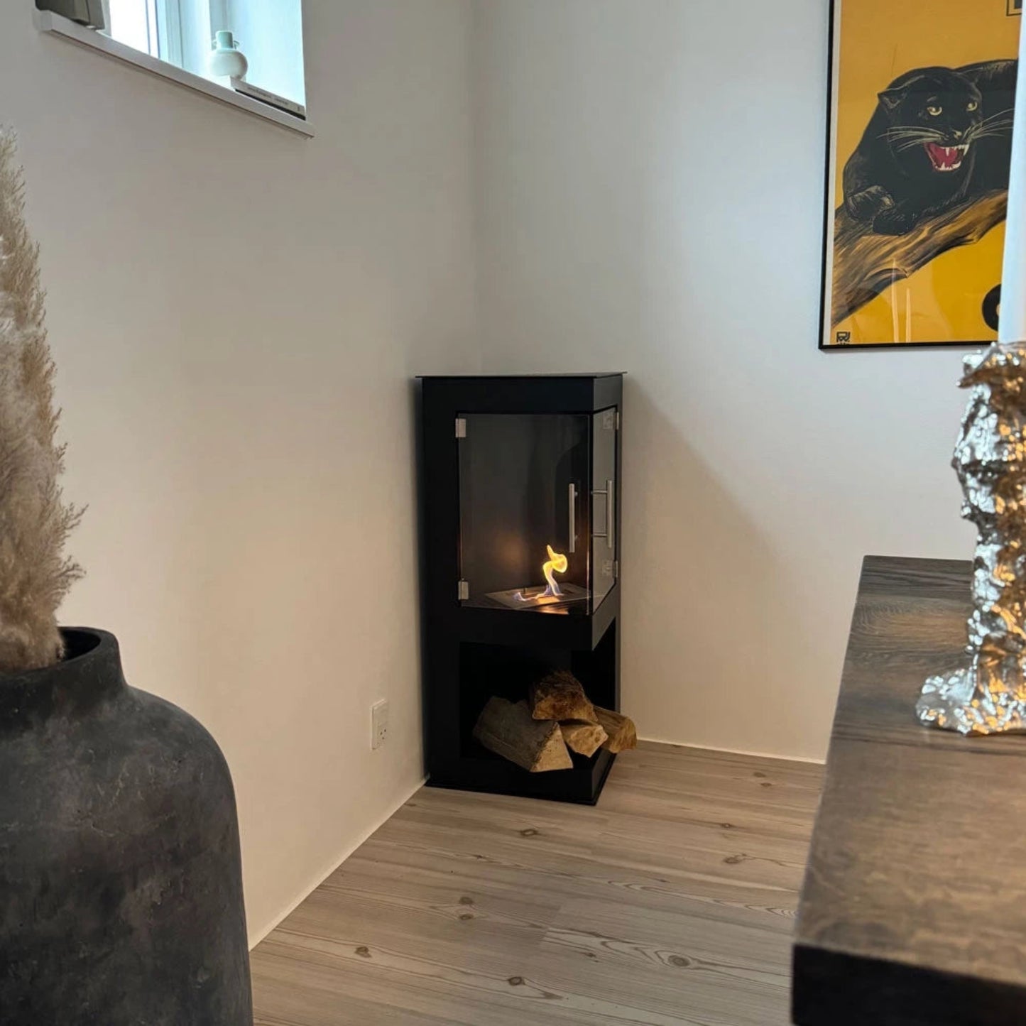 Modern black freestanding fireplace in a room with decorative elements.