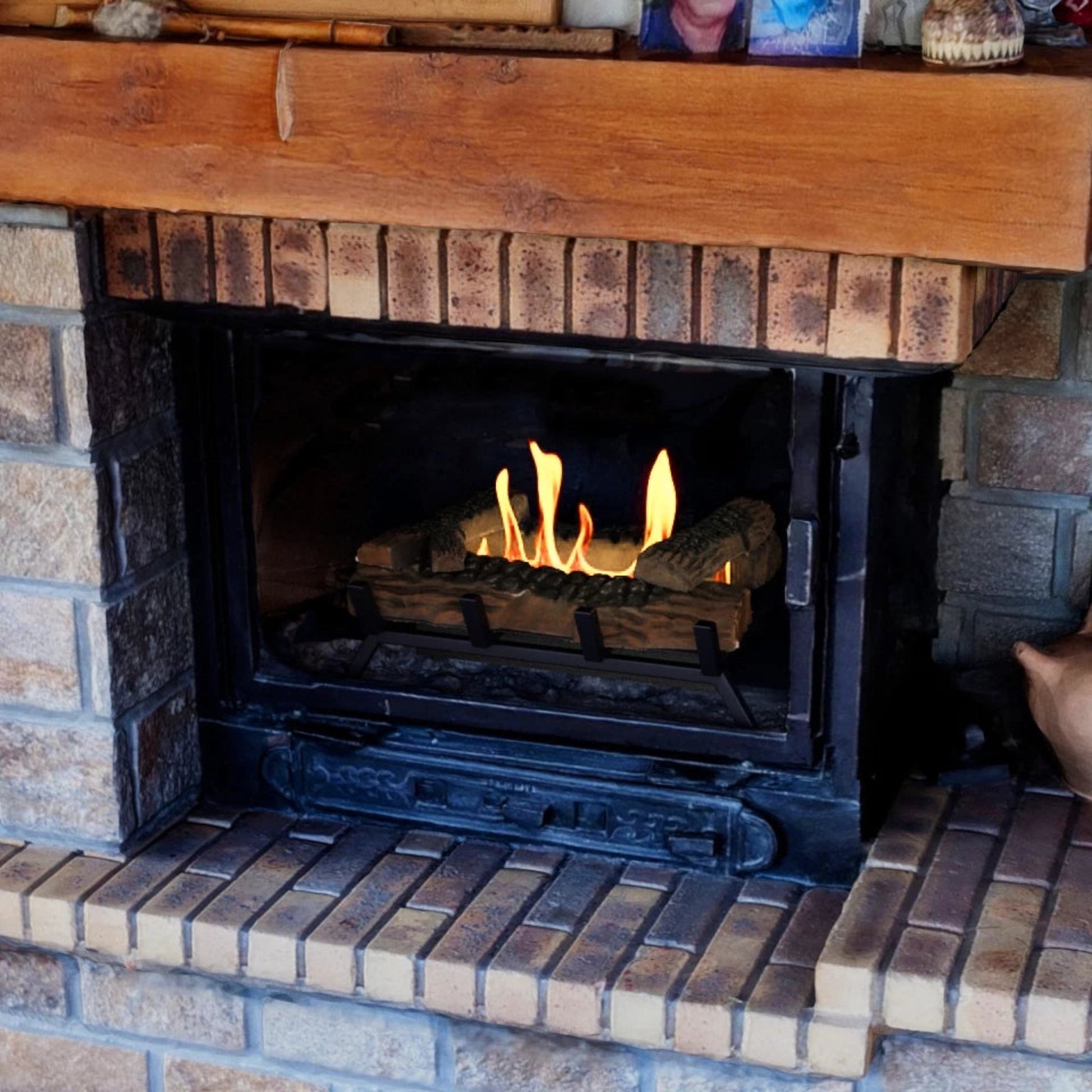 Brick fireplace with ScandiFlames 40cm Bioethanol Fire Grate burning inside and wooden mantel above.