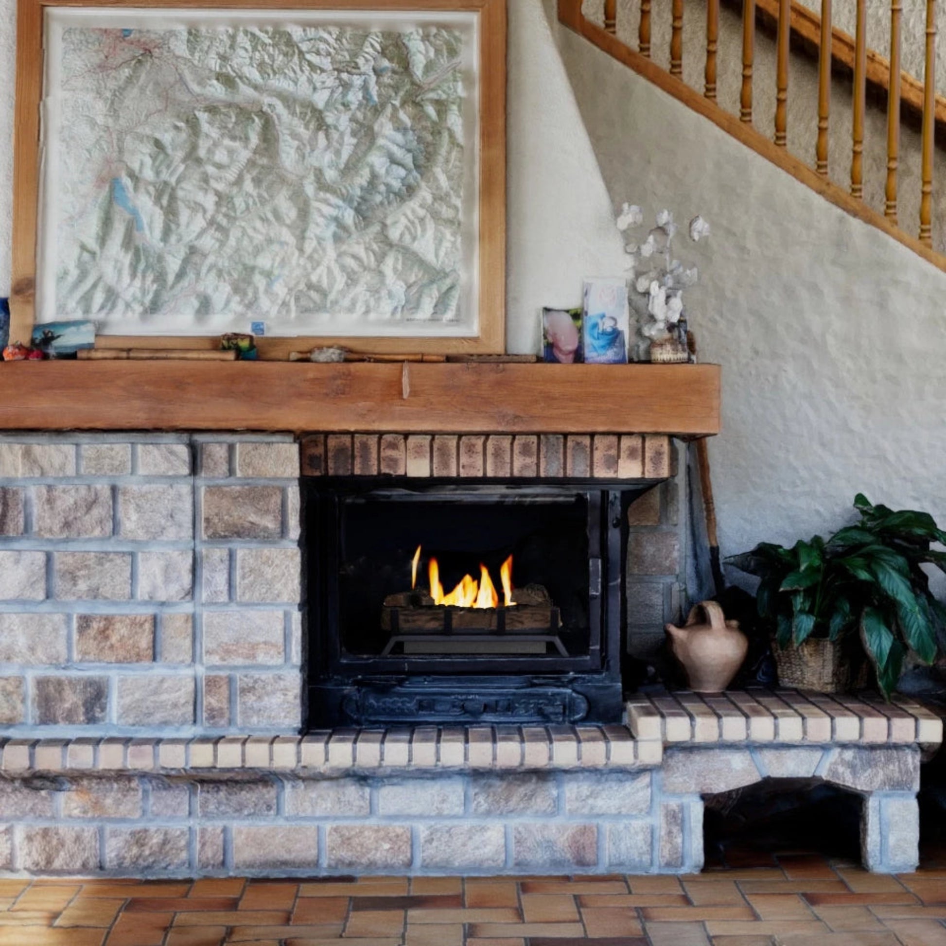 Brick fireplace with ScandiFlames 40cm Bioethanol Fire Grate with wooden mantel and framed artwork above it.