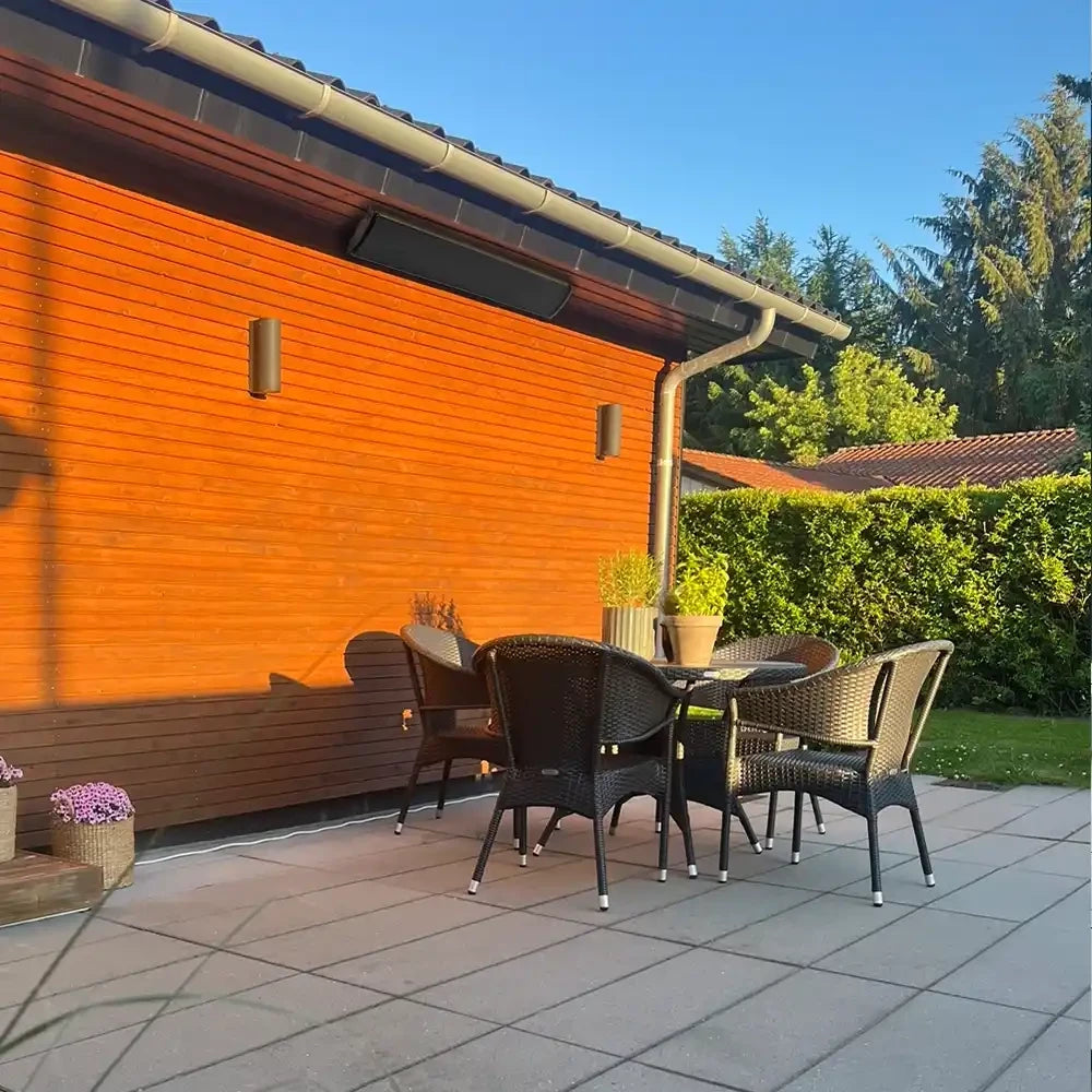Outdoor patio area with wicker chairs and table against an orange wall.