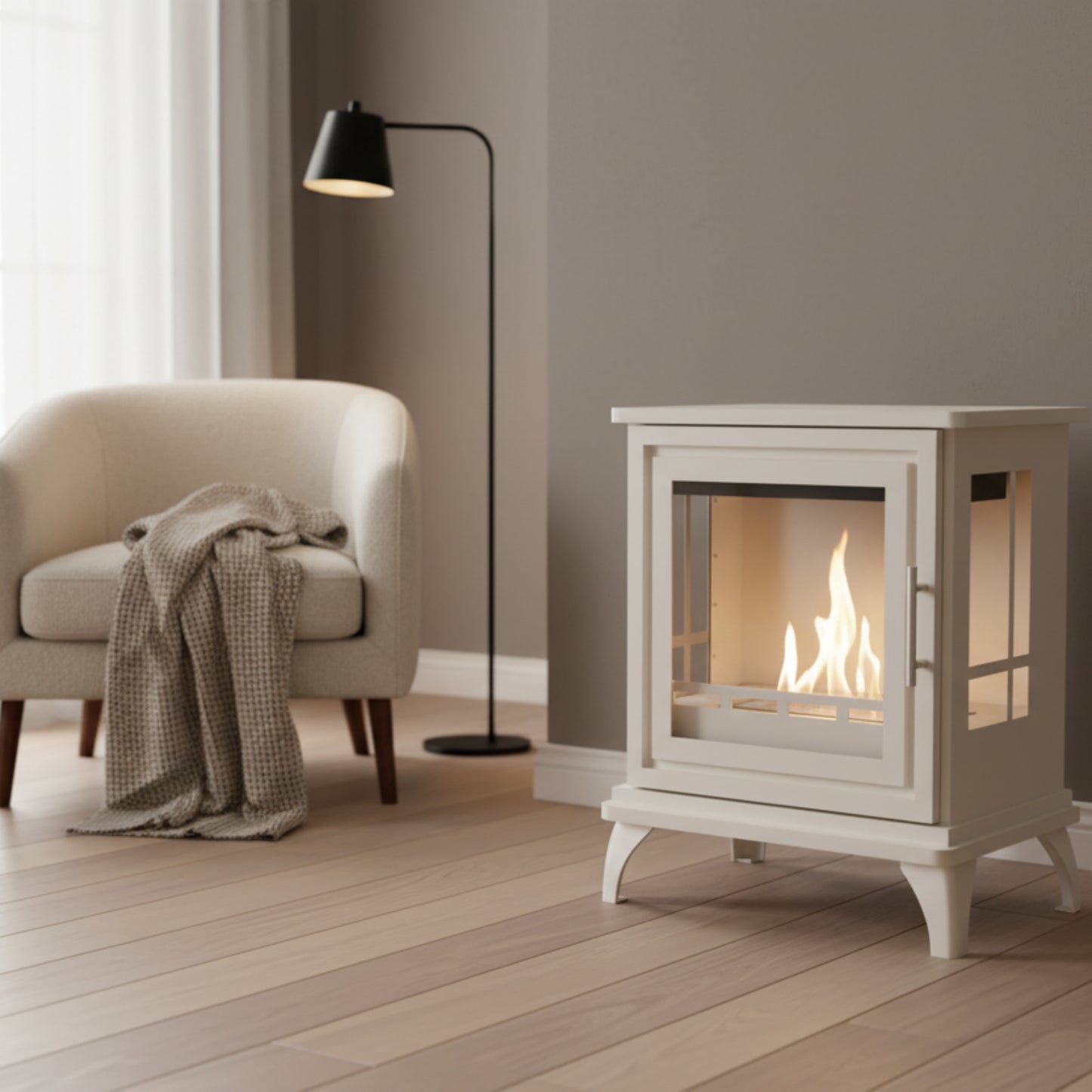 Oyster white freestanding fireplace with glass door in a dark cream room with a standard lamp, a chair and thrwo.