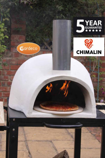 White outdoor pizza oven with fire inside, on a brick patio with 'Gardeco' and 'Chimalin' branding.