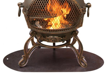 An antique-style metal fire pit with a mesh screen and glowing orange flames inside, supported by ornate legs and sitting on an oval dark base against a white background.
