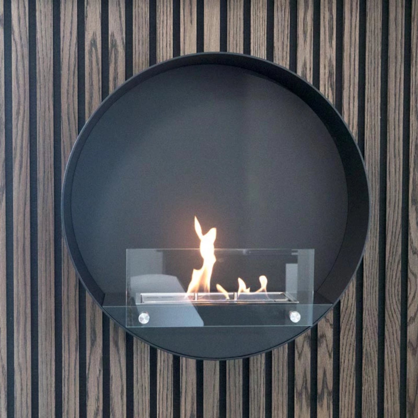 Round bio ethanol fireplace with flames on a striped wall background
