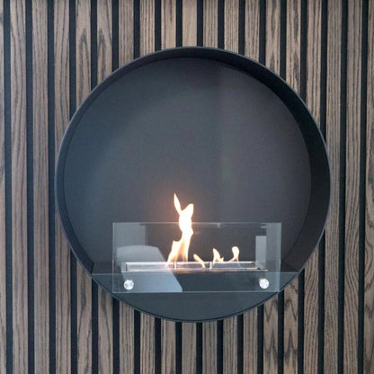 Round bio ethanol fireplace with flames on a striped wall background